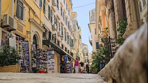Ground level-Light pedestrian traffic-Yellow shops Stock Footage 296354409