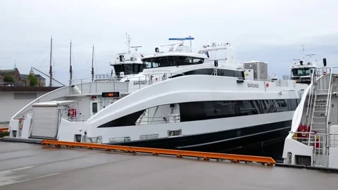 Ground level modern white passenger ferries quay curved hulls tinted windows Stock Footage 327631022