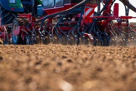 Ground Level Seed Drill and Tractor Depositing Seed in Tilled Soil Stock Photos