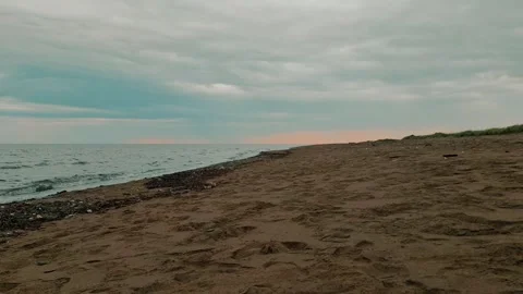 Ground Level Shot Above The Sand On A Beach With Gentle Waves Rolling Into Shore Stock Footage 255322070