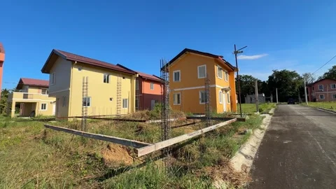 Ground level shot of a construction site beside completed houses, highlighting 動画素材 332600251
