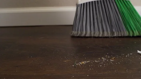 Ground level slider shot of broom, dustpan and debris on hardwood floor Stock-Footage 122054754