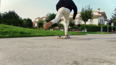 Ground-Level Slow Motion Shot of a Skater Jumping on the Board in 4K Stock Footage 285765924
