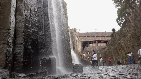 Ground Level View of Basalt Waterfall Canyon and Towering Stone Cliffs in Vídeo Stock 335447815