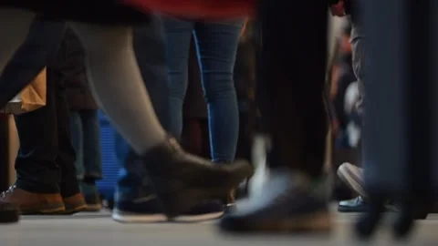 Ground-level view in a busy station, showing only shoes and legs of hurried.. Video stock 302797765