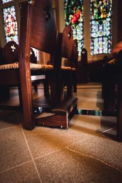 Ground level view of kneeling bench rows in a church used for praying. Foto stock