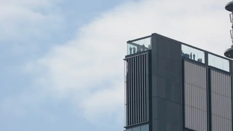 Ground level view looking up at modern skyscraper rooftop observation deck Video stock 333651130