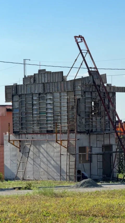 Ground level view of a man doing construction work, handling materials at a 스톡 동영상 332613096