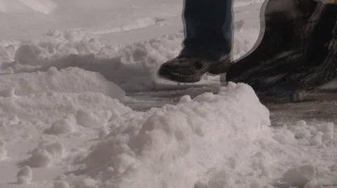 Ground level view of man's legs and snow shovel clearing snow Stock-Footage 47343396