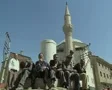 Ground level view of men sitting outside mosque SD Footage
