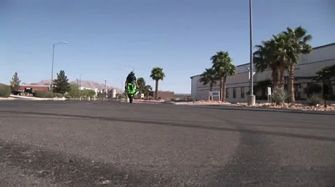 Ground Level View Of a Rider Doing A Back Tire Wheelie 2 動画素材 18972448