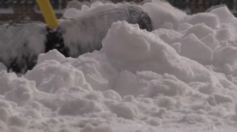 Ground level view of snow shovel clearing a pile of snow. Stock-Footage 47345145