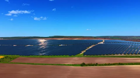 Ground level view of solar farm extending across flat farmland. Low angle Stock Footage 336386467