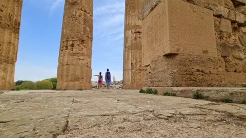 Ground level view toward mother and child at Greek temple colonnade Stockbeeldmateriaal 279844740