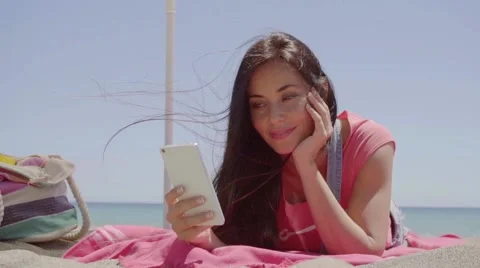 Ground level view of woman using phone at beach Stock Footage 62946409