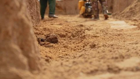 Ground level view of workers compacting sand at construction site Stock Photos