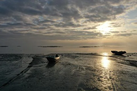 At ground level on Xiamen's tidal flat, two fishing boats rest in the foregro Stock Photos