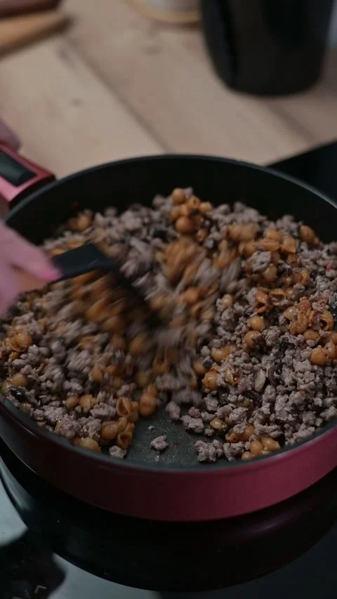 Ground meat is cooked in a skillet as it is stirred with a spatula. The texture Видео 337112226