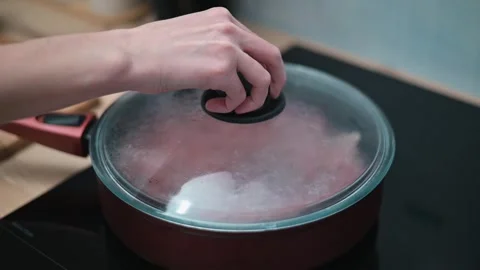 Ground meat is placed in a pan and cooked with a lid. The process shows stages Видео 337112183