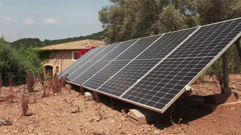 A ground-mounted solar panel array generates renewable energy on a Stock Footage 337589950