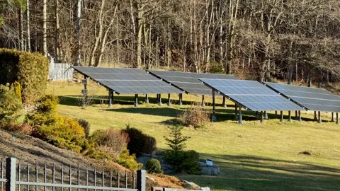 Ground mounted solar panels array situated on a grassy hill during sunny Vídeo Stock 345822584