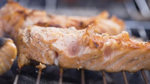 Ground pepper sprinkled on the fish while on grill Stock Footage 85828803