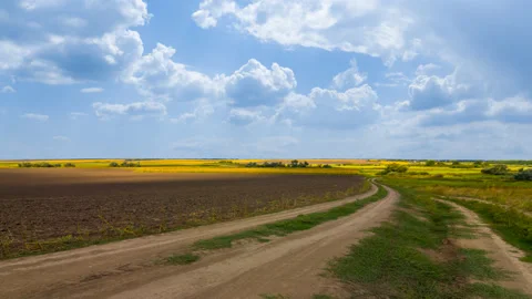 Ground road among rural fields under cloudy sky time lapse scene Stock Footage 194171625