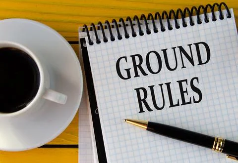 GROUND RULES - words on a white sheet on a yellow wooden background with a pe Stock Photos