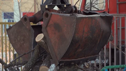On the ground scattered sawed trees. Crane manipulator captures several trees at Video stock 100209810
