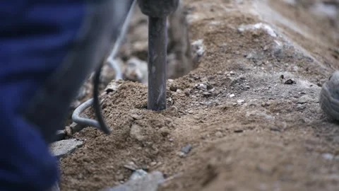Ground tool work an electric jackhammer digging into concrete in slow motion Stock Footage 330119575