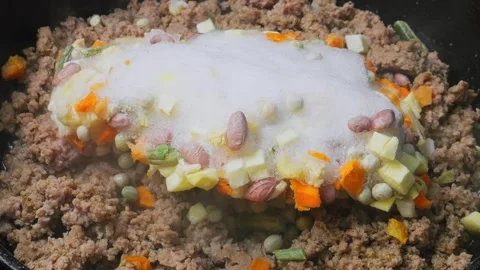 Ground turkey is fried in a frying pan in vegetable oil with frozen vegetables 库存影片 308764225