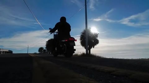 Ground view of motorcycle riding off into sunset Video stock 45292561
