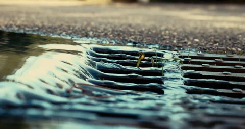 Ground view of water flowing down a manhole Stock Footage 270388431