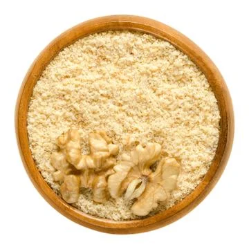 Ground walnuts and walnut kernel halves in wooden bowl Stock Photos