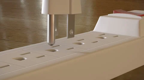 A grounded electric plug with  prongs is inserted into an outlet strip Stock Footage 62200491