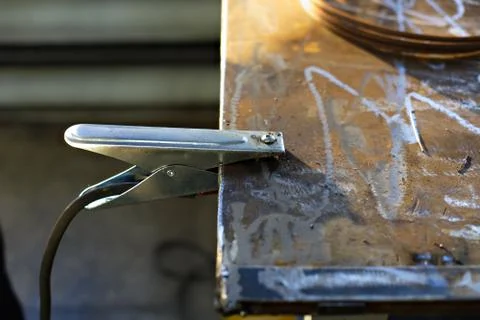 The grounding clamp with the cable from the welding machine is fixed to the m Stock Photos