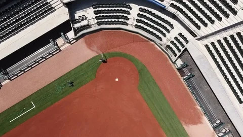 Grounds Crew member waters softball field infield - aerial Stock Footage 104427150