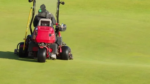 Groundskeeper Operating Lawn Mower on Golf Course Green Vidéo 318502119