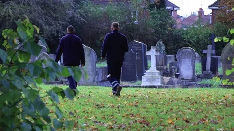 Groundsmen working for the cemetery searching for a long lost marker Stock Footage 254745802