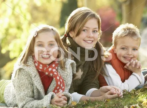 Group of 3 children realxing outdoors in autumn landscape Stock Photos