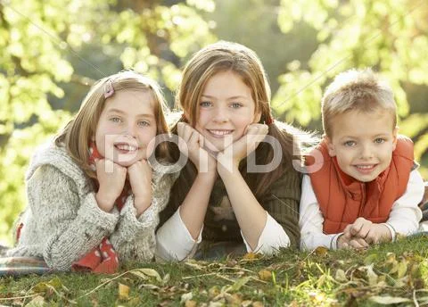 Group of 3 children realxing outdoors in autumn landscape Stock Photos