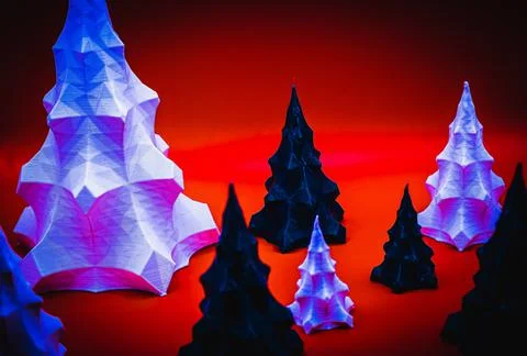 A group of 3D printed objects that look like Christmas trees against a red ba 写真素材