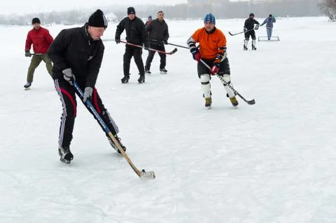 Group of active different aged people playing hokey on a frozen river Dnipro Stock Photos
