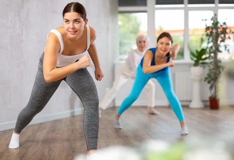 Group of active women practicing energetic dance in modern dance studio Stock Photos