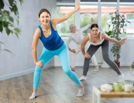 Group of active women practicing energetic dance in modern dance studio Stock Photos