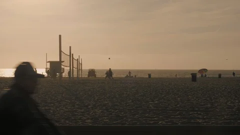 Group of active young people playing volleyball on beach at sunset Stock Footage 126900567