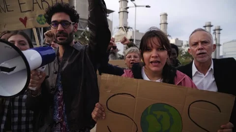 Group of activists gathered to protest climate change, displaying banners Stock Footage 274879905
