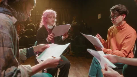 Group of Actors Sitting in Circle on Stage and Reading Printed Scripts Stock Footage 247800458