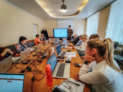 A group of adults attends a computer training or business workshop Stock Photos