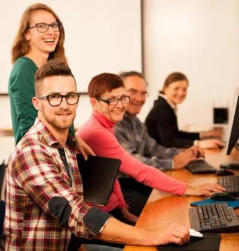 Group of adults learning computer skills. Intergenerational transfer of knowl Foto stock